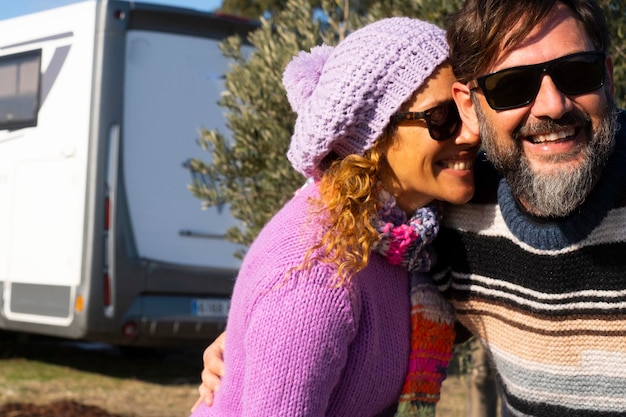 행복한 여행자 커플이 시골에서 셀카를 찍고 배경에는 현대적인 캠핑 밴 모터호네 RV 차량이 주차되어 있습니다. 행복한 남녀 여행 라이프 스타일 관광 관광 아웃도어