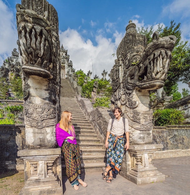 Happy couple of tourists on background of three stone ladders in beautiful pura lempuyang luhur