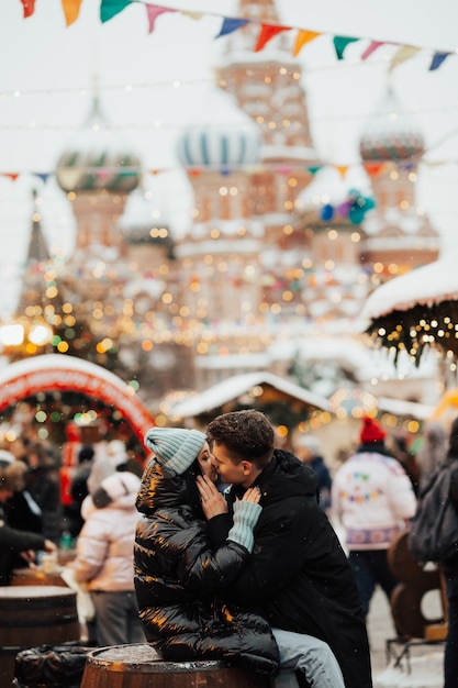 Happy couple of tourists kissing next to Saint Basil's Cathedral