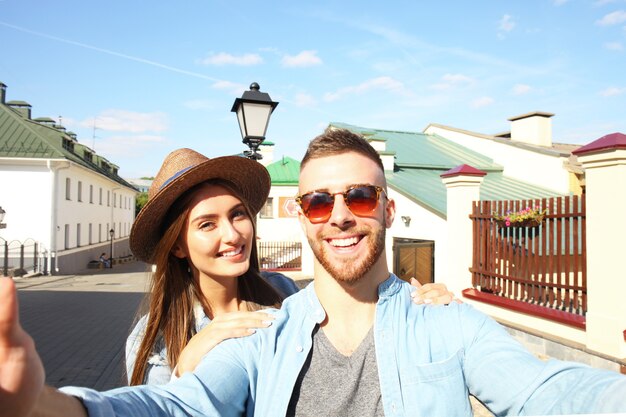 Happy couple of tourists taking selfie in old city.