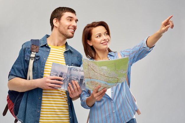 Photo happy couple of tourists with city guide and map