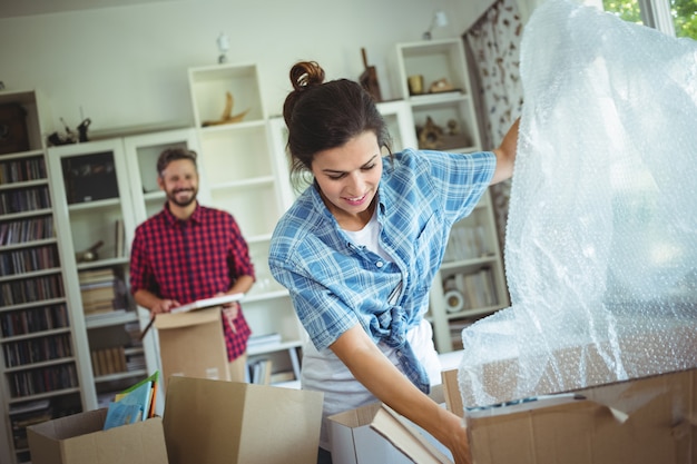 Happy couple unpackingcarton boxes together