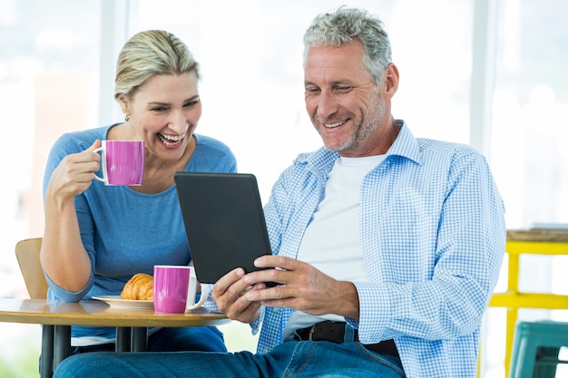 Happy couple using digital tablet