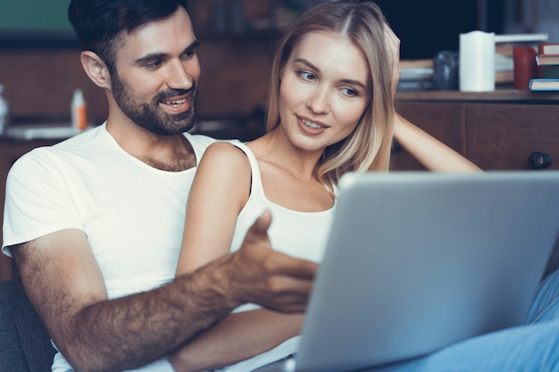 Happy couple using a laptop on the sofa.