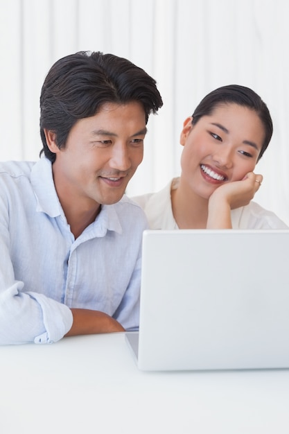 Happy couple using laptop together