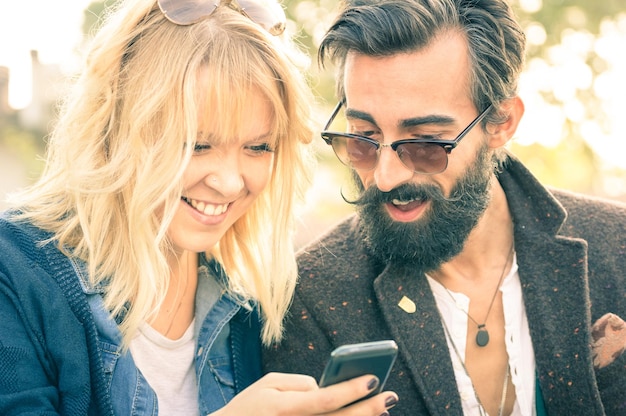 Photo happy couple using smart phone outdoors