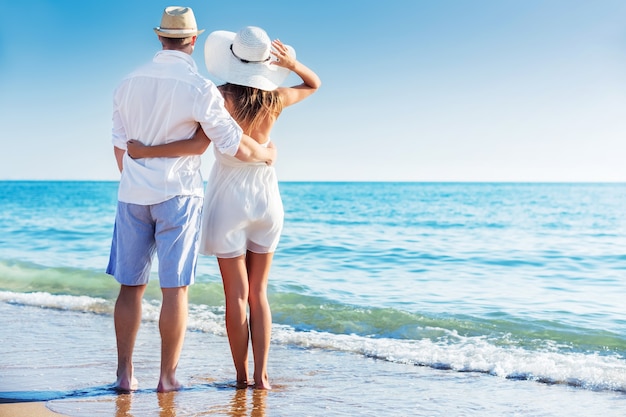 Happy Couple walking on beach at seaside