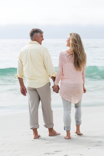 Happy couple walking by the sea