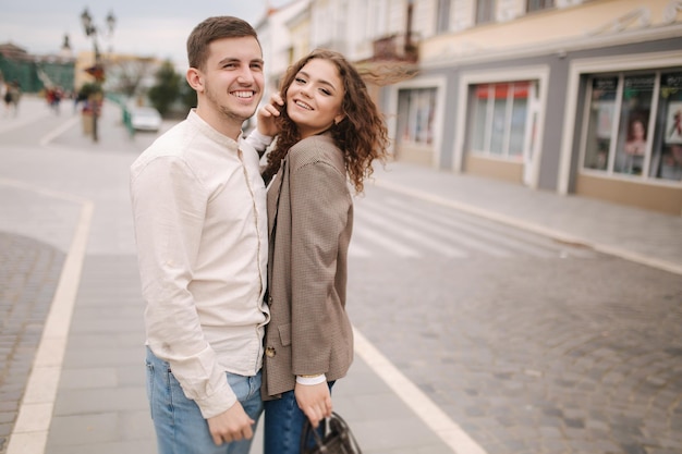 Happy couple walking in the city Attractive young woman and handsome young man in centre of the city Smiled people