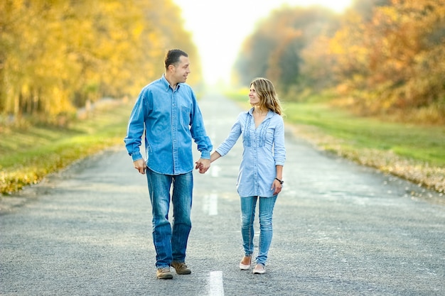 Happy couple walking on the road in nature in the park travel