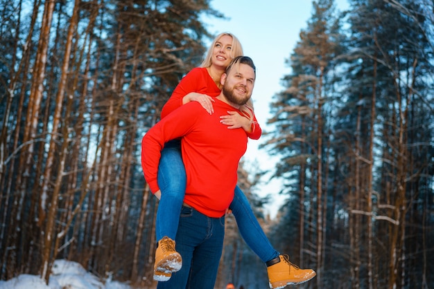 Happy couple walking in the snowy forest