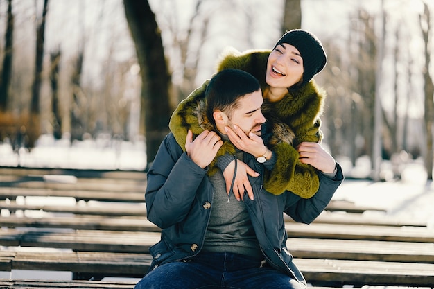 happy couple walking through the park on a sunny winter day