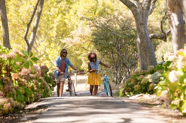 Happy couple walking with bicycle