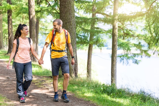 Happy couple walking in the wood holding hands