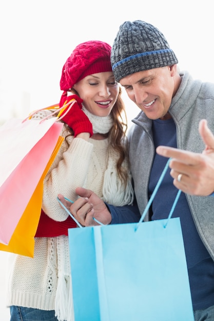 Happy couple in warm clothing with shopping bags