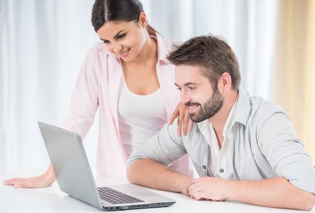 Happy couple watching movie on laptop.