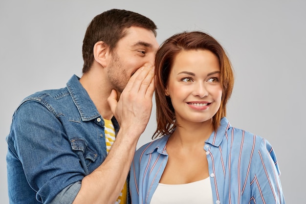 Photo happy couple whispering over grey background