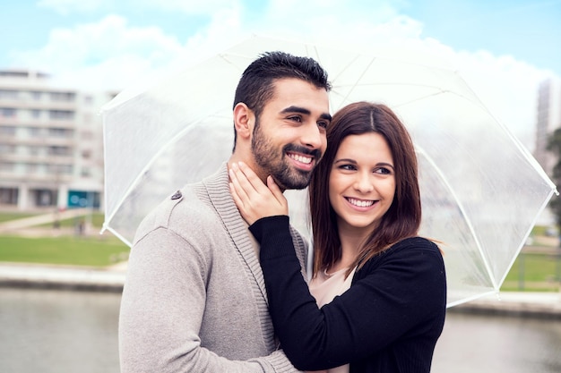 Happy couple under a white umbrella in the city