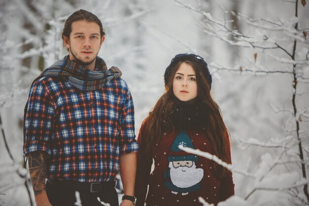 Happy couple in winter clothes walking outdoors in park