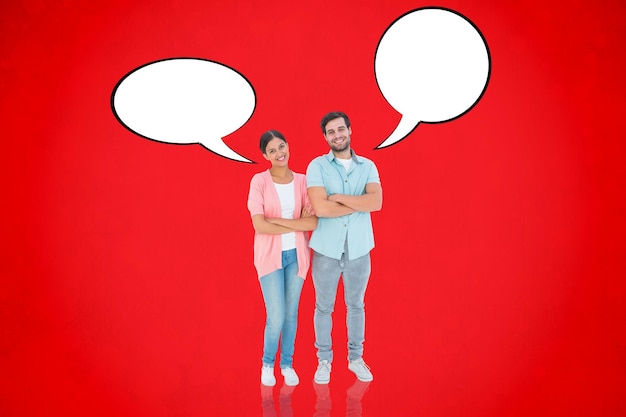 Happy couple with arms crossed against red background