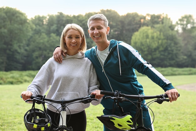 Happy couple with bicycles in park Healthy lifestyle