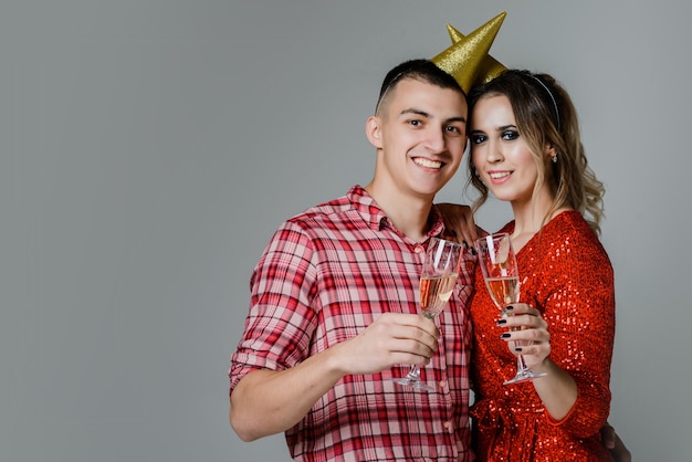 happy couple with bottle of champagne and glasses over gray