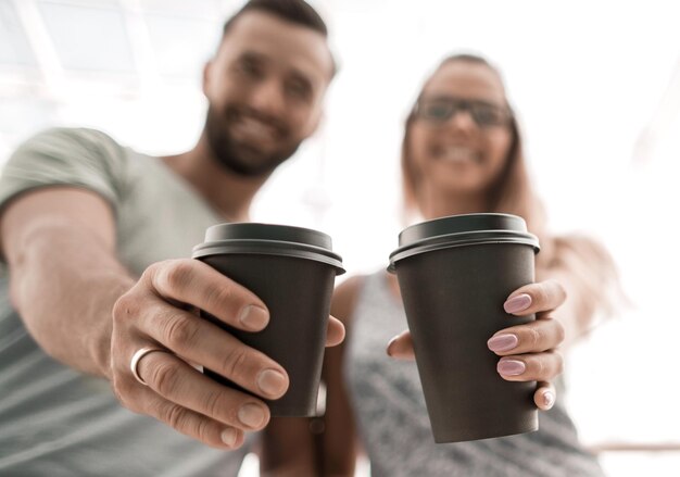 Photo happy couple with cups of hot coffee