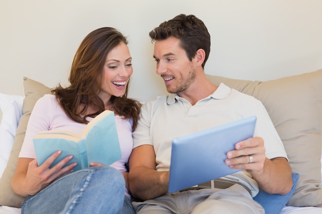 Photo happy couple with laptop and book on couch
