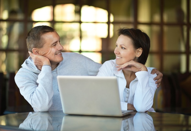 Happy couple with laptop at the table