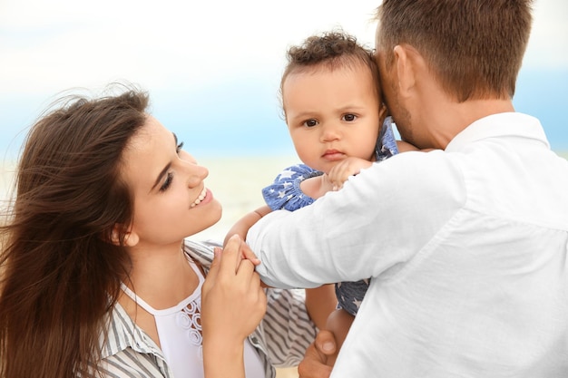 Happy couple with little daughter on beach