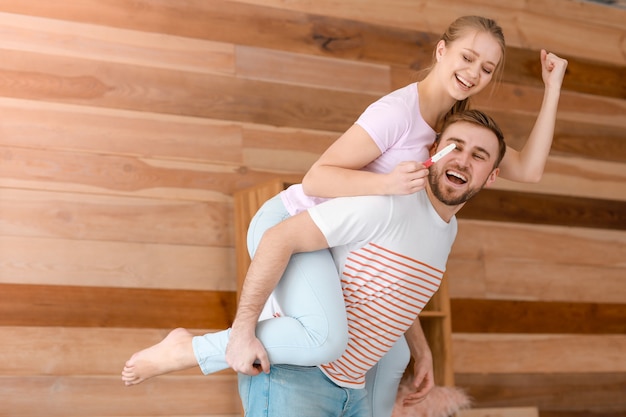 Happy couple with pregnancy test at home