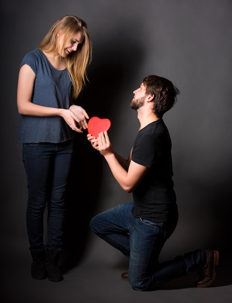 Happy couple with red heart on a dark background