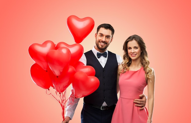 happy couple with red heart shaped balloons