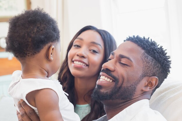 Happy couple with their baby girl on couch