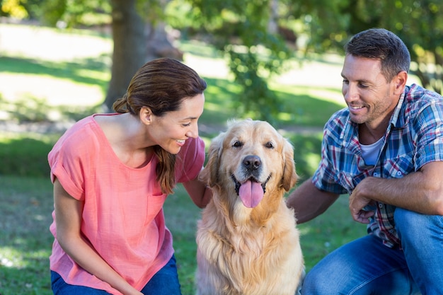 Happy couple with their dog in the park