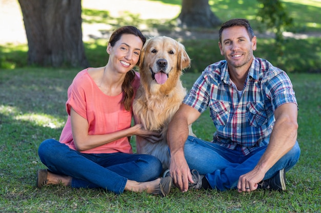 Happy couple with their dog in the park