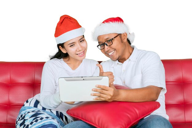 Счастливая пара с большим пальцем и планшетом на Рождество