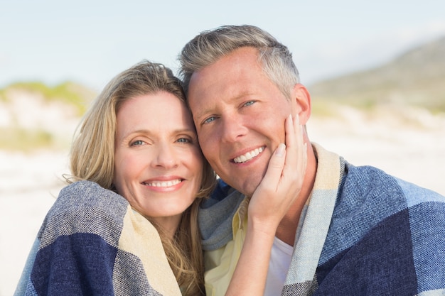 Photo happy couple wrapped up in blanket