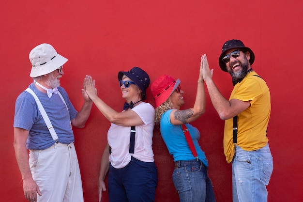 Foto coppie felici che fanno il high-five sullo sfondo rosso.