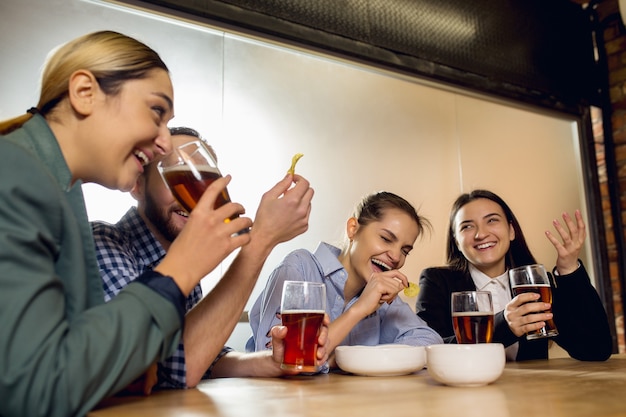 I colleghi felici che celebrano l'evento aziendale dopo una giornata di lavoro tesa sembrano felici e amichevoli