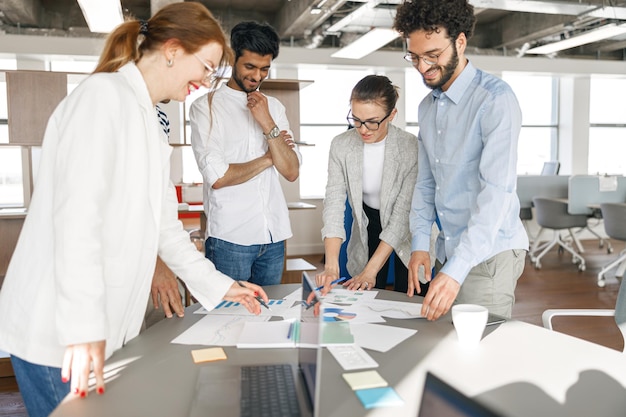 Happy coworkers cooperating and working together at office meeting teamwork concept