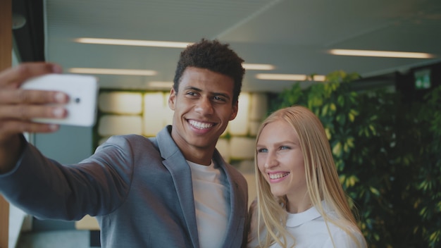 Happy coworkers taking a selfie in the office