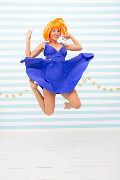 Happy crazy woman jumping in studio background full length of crazy woman