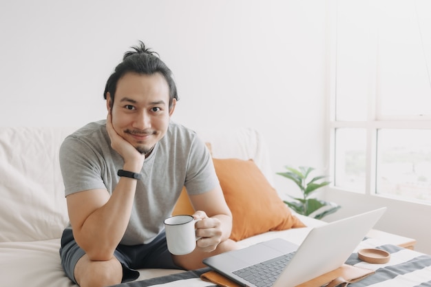 Happy creative man work on laptop in his home office apartment