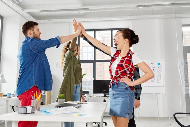 Photo happy creative team making high five at office