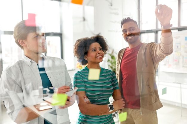 Photo happy creative team at office glass board