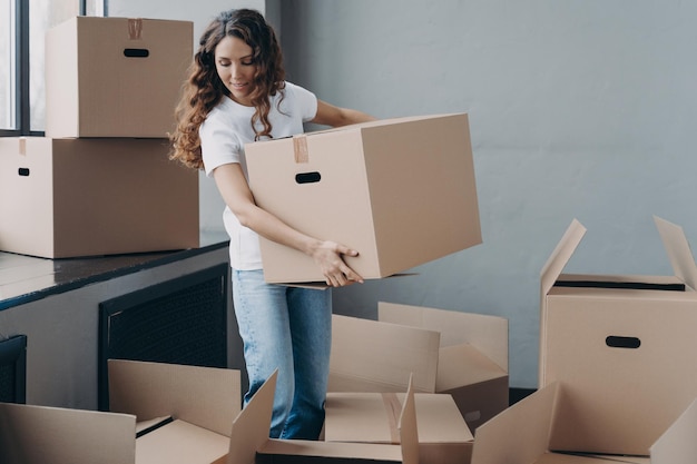 Happy curly girl carrying box and relocating Real estate and property advertising mockup concept