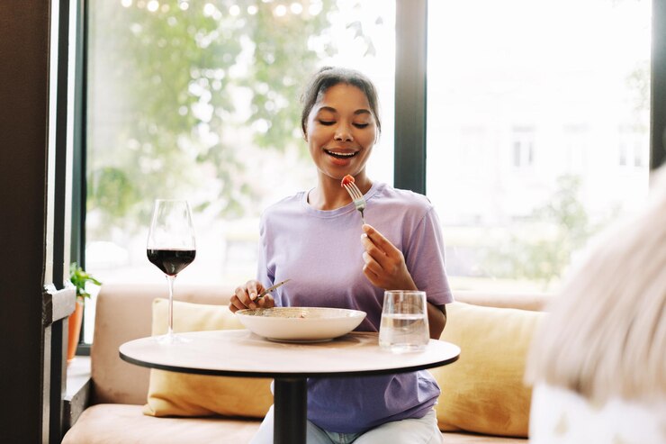 Photo happy customer attractive african american woman enjoying delicious meal in restaurant by window