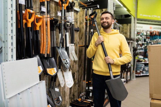 Happy customer chooses gardening shovel shop of goods for gardeners and those who are fond of