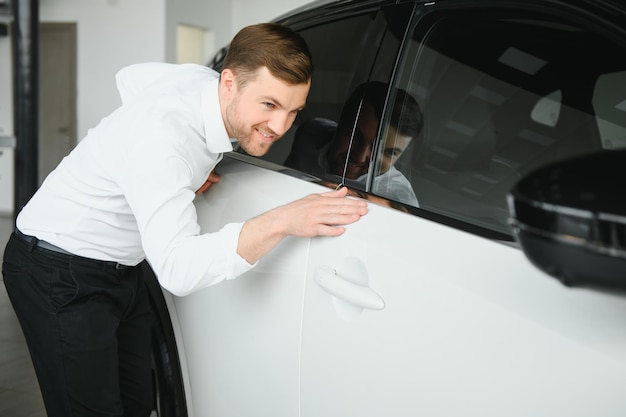 Foto cliente soddisfatto ha appena acquistato un'auto presso un concessionario